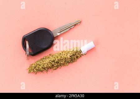 Fahren unter dem Einfluss von Cannabis oder Marihuana, hohes Fahren, Fahren bei eingeschränkter Fahrweise, Autoschlüssel mit Cannabis Stockfoto