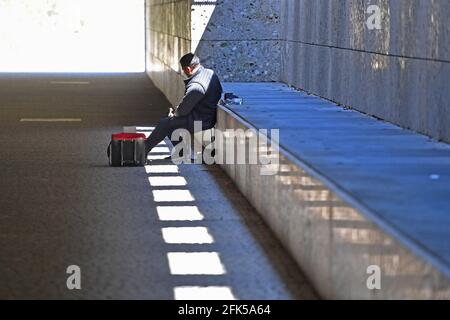 München, Deutschland. April 2021. Straßenmusiker in Zeiten der Coronavirus-Pandemie: Am 28. April 2021 sitzt ein Musiker untätig in einer Unterführung in München. Credit: dpa/Alamy Live News Stockfoto