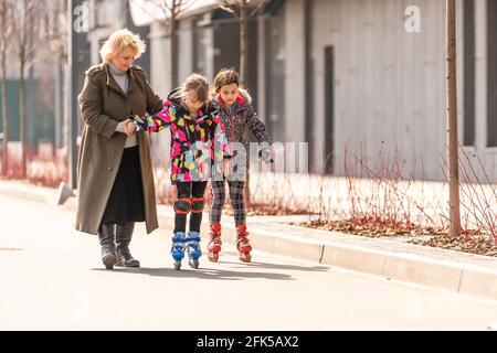 Großmutter lehrt Enkelin Rollschuh Stockfoto