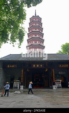 Zwei Reinigungskräfte räumen vor einem Gebäude im Six Banyan Temple Complex im Zentrum von Guangzhou, China, auf Stockfoto