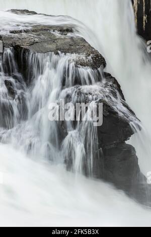 Das Wasser des Spokane River fließt schnell über große Felsen am Post Falls Dam in Post Falls, Idaho. Stockfoto