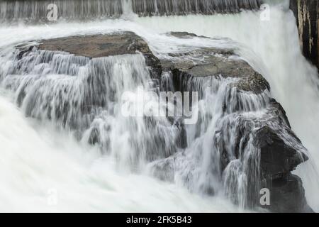 Das Wasser des Spokane River fließt schnell über große Felsen am Post Falls Dam in Post Falls, Idaho. Stockfoto