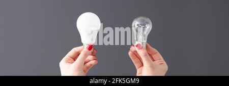 Frau mit zwei verschiedenen Glühbirnen in den Händen Nahaufnahme Stockfoto