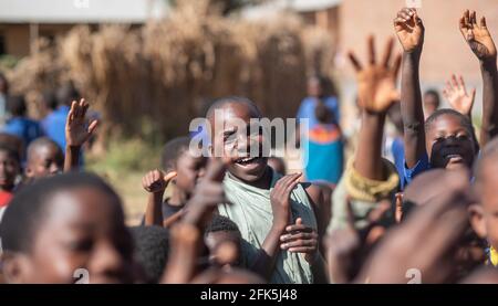 Mzuzu, Malawi. 30-05-2018. Schwarze Studenten versammeln sich vor dem Klassenzimmer, lächeln und amüsieren sich, bevor sie nach Hause gehen, um in einem ländlichen Dorf in Ma zu Mittag zu essen Stockfoto