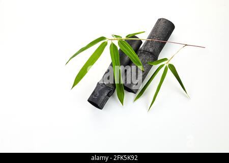 Natürliche Bambusholzkohle mit isolierten Blättern auf weißem Hintergrund Stockfoto