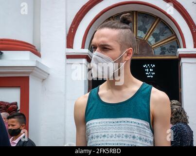 Guatape, Antioquia, Kolumbien - April 4 2021: Kaukasischer blonder Mann, der aus dem Hören der Kirchenmesse kommt Stockfoto