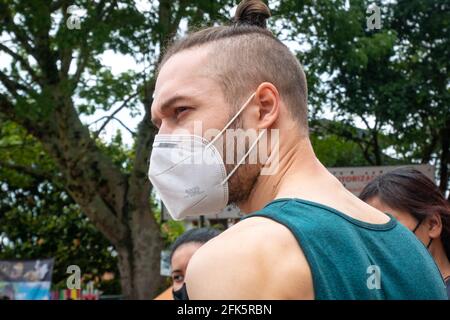 Guatape, Antioquia, Kolumbien - April 4 2021: Kaukasischer blonder Mann steht vor dem Park voller Bäume Stockfoto