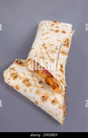 Blick von oben auf den Döner mit Fleisch- und Gemüsefüllung auf grauem Hintergrund. Stockfoto