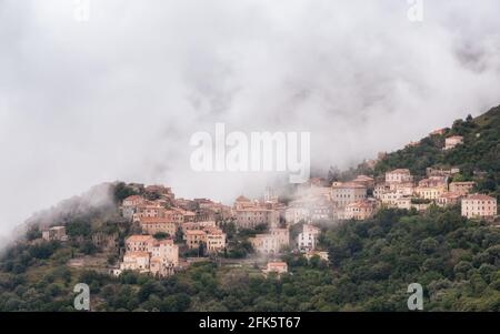 Bergdorf Belgodere, umgeben von Wäldern in der Balagne Region Korsika unter einer Decke von niedrigen Wolken Stockfoto