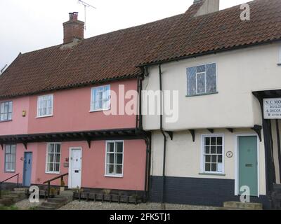 Eine Reihe von Reihenhäusern im Dorf Debenham mit dem traditionellen Suffolk pastellfarbenen Rendering an den Wänden. Stockfoto