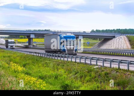 Lkw bewegen unter einem viaduck. Gegenverkehr. Stockfoto