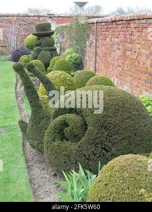 Eine riesige Schnecke und ein Schneemann sind an der oberen Grenze im ummauerten Garten in Helmingham Hall, Suffolk, zu sehen. Stockfoto