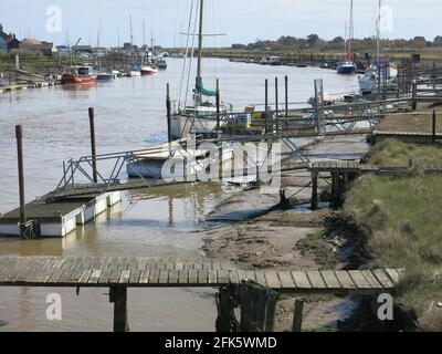 Verschiedene Boote, die an Anlegestegen auf der Walberswick-Seite des Flusses Blyth festgemacht wurden; Suffolk Küstenlandschaft Ende April 2021. Stockfoto