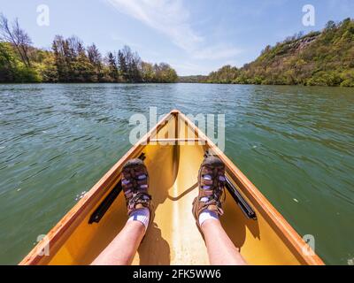 Kaukasischer Mann, der in einem Packkanu den Monongahela-Fluss in Morgantown, West Virginia, hinunter paddelt Stockfoto