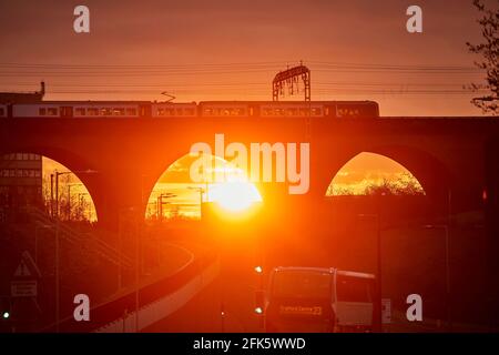 Sonnenaufgang im Stockport Viaduct, Greater Manchester. Ein Nahverkehrszug mit dem Northern Stockfoto