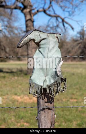 Ein alter Cowboystiefel hängt an einem Zaun in Texas Hill Country Stockfoto