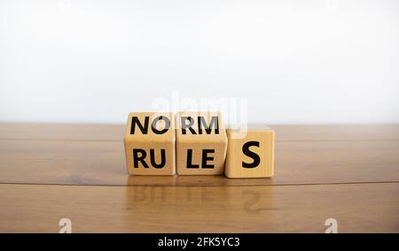 Symbol für Regeln oder Normen. Drehte Würfel und änderte das Wort „Normen“ in „Regeln“. Schöner Holztisch, weißer Hintergrund, Kopierraum. Business und Regeln Stockfoto
