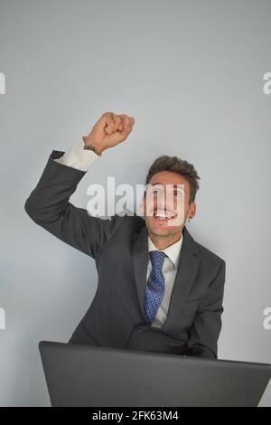 Fröhlicher junger Unternehmer mit erhobener Faust feiert ein Erfolgreicher Deal Stockfoto