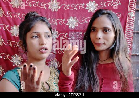 Low-Angle-Aufnahme zweier junger indischer Freundinnen, die diskutieren Etwas Stockfoto