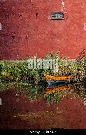 Die Mauern der Burg Malmo und ein kleines Boot, das in einem Wassergraben reflektiert wird, Schweden Stockfoto