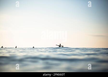 Asiatische Frau mit Spaß in Surf-Lineup auf einem frühen Sommermorgen Stockfoto