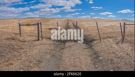 Pfad und Tor in einem Stacheldrahtzaun in der Nähe von Cochrane, Alberta, Kanada Stockfoto