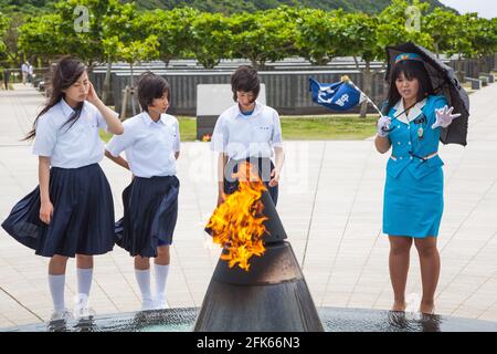 Japanischer Reiseleiter, der junge Schüler über die Schlacht von Okinawa während des Zweiten Weltkriegs, Peace Memorial Park, Naha, Okinawa, Japan, unterrichtet Stockfoto