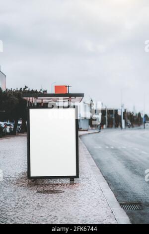Vertikale Ansicht einer Bushaltestelle mit einem weißen, leeren Platzhalterbild einer Werbetafel; eine leere Vorlage eines Werbeplakats auf der öffentlichen tra Stockfoto