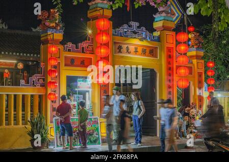 Rote Laternen Beleuchtung verzierter gelber chinesischer Tempel nach der Dämmerung, Altstadt, Hoi an, Vietnam Stockfoto