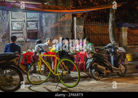 Vietnamesische Familie, die am Abend vom Street Food Stand isst, Hoi an, Vietnam Stockfoto