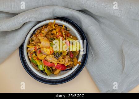 Gebratenes würziges Wildschwein mit rotem Chili in einer weißen Schüssel umrühren. Selektiver Fokus. Stockfoto