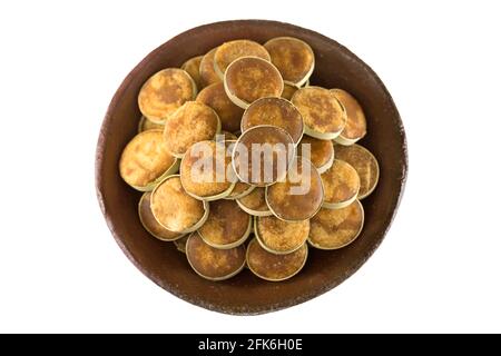 Tonschüssel voll mit Jaggery-Zucker aus asiatischem Palmyra-palmsaft, gefüllt in Scheiben von kleinen getrockneten Palmblättern, isoliert auf weißem Hintergrund Stockfoto