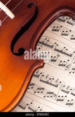 Alte Geige auf dem Notenblatt liegend, Musikkonzept. Stockfoto