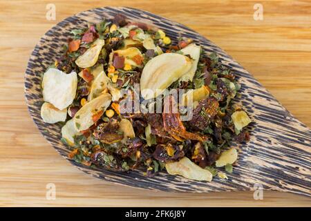 Holzlöffel getrocknete würzige rote Chilischoten, Knoblauch in Scheiben geschnitten, Petersilie, um italienische Spaghetti aglio e olio zu machen Stockfoto