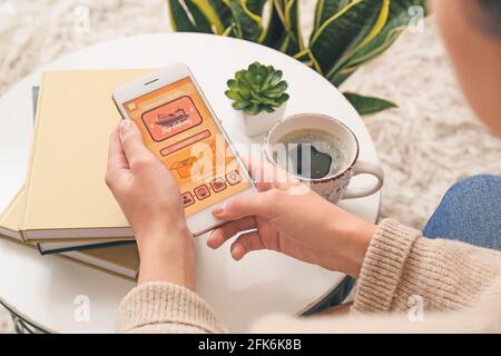 Frau mit Mobiltelefon mit offener Seite des Zustelldienstes Anwendung zu Hause Stockfoto