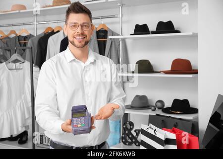 Verkäufer mit Zahlungsterminal im modernen Shop Stockfoto