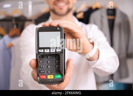 Verkäufer mit Zahlungsterminal im modernen Shop Stockfoto