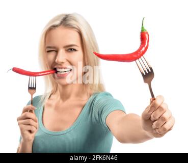 Schöne junge Frau essen scharfe Chilischoten auf weißem Hintergrund Stockfoto