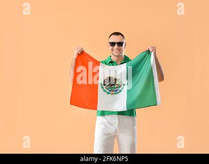 Junger Mann mit mexikanischer Flagge auf farbigem Hintergrund Stockfoto