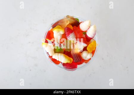 Glas leckere Gelee-Bonbons auf hellem Hintergrund Stockfoto