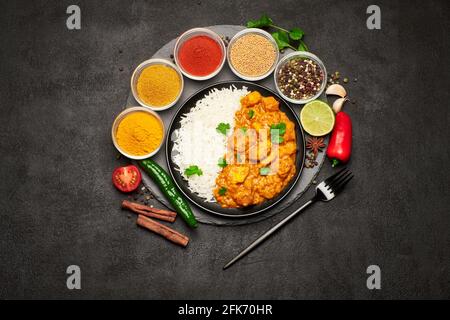 Teller mit traditionellem Chicken Curry und Gewürzsatz Dunkler Betonhintergrund Stockfoto