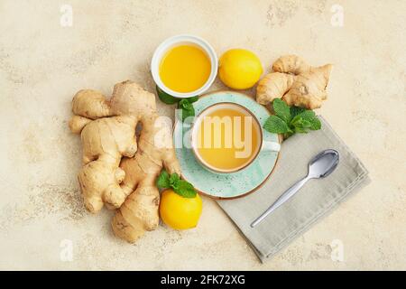 Tasse Tee mit Ingwer, Honig und Zitronen auf hellem Hintergrund Stockfoto