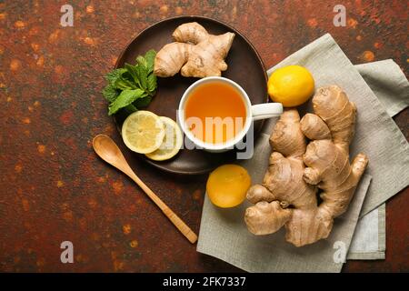 Tasse Tee mit Ingwer, Minze und Zitronen auf grünem Hintergrund Stockfoto