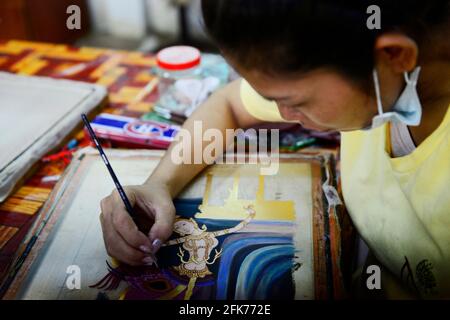 Eine kambodschanische Malerin, die in der Werkstatt Artisans d'Angkor in Siem Reap, Kambodscha, an ihrer traditionellen Khmer-Malerei arbeitet. Stockfoto