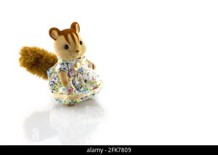 Mädchen Eichhörnchen Spielzeug trägt Kleid auf weißem Hintergrund Stockfoto