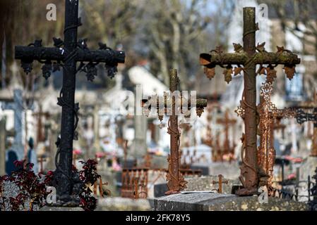 Ein altes rostiges katholisches Kreuz auf einem Friedhof in Frankreich. Stockfoto