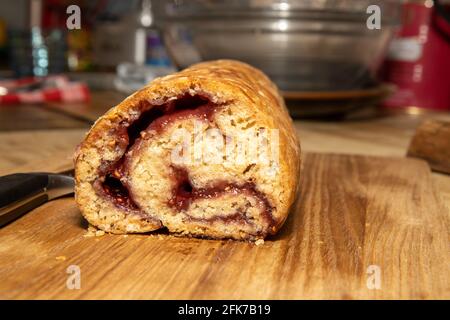 Ein köstliches traditionelles britisches Jam Roly-Poly Dessert auf einem hölzernen Küchentisch Stockfoto