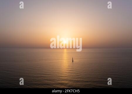 Segeln Sie mit dem Boot langsam zu einer untergeht Sonne im Mittelmeer. Stockfoto