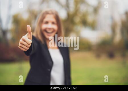 Porträt einer glücklichen Geschäftsfrau im Freien. Die blonde Geschäftsfrau steht draußen und lächelt. Stockfoto