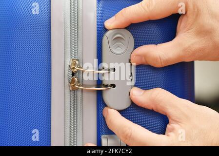 Männliche Hände öffnen das Kombinationsschloss am Koffer Stockfoto